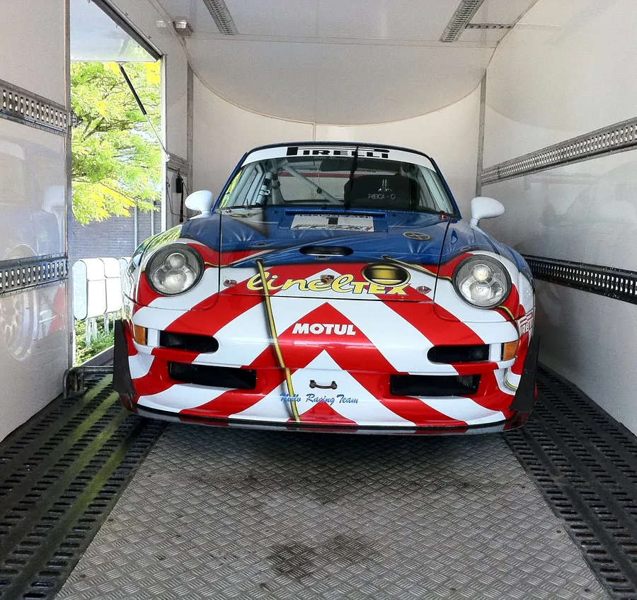 Porsche 911 RS rojo en un camión cerrado exclusivo JDC-Trans