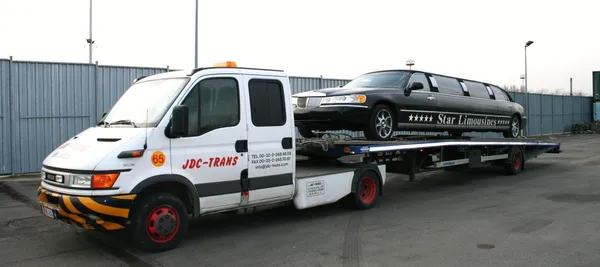 Plataforma JDC-Trans Iveco transportando una limusina stretch negra de Star Limousines