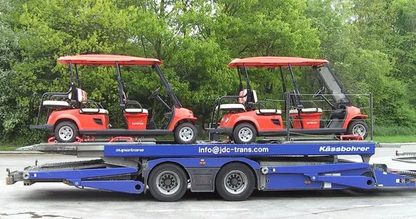 Trailer JDC-Trans cargado de carritos de golf rojos