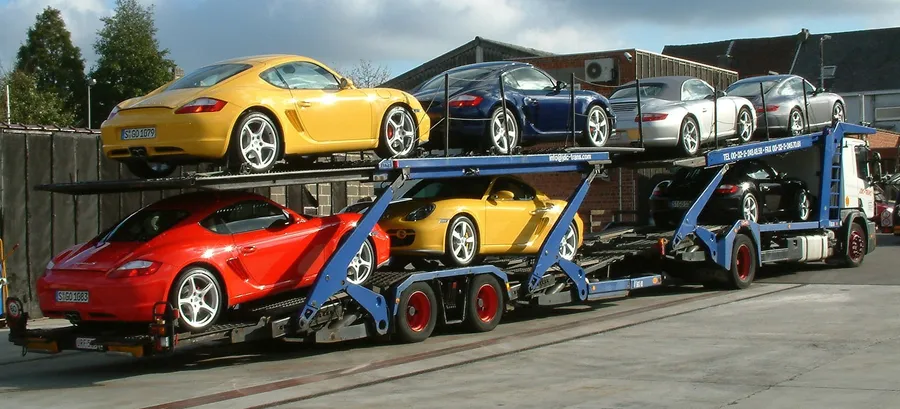 Plataforma abierta JDC-Trans cargada de Porsches Cayman y Boxster coloridos