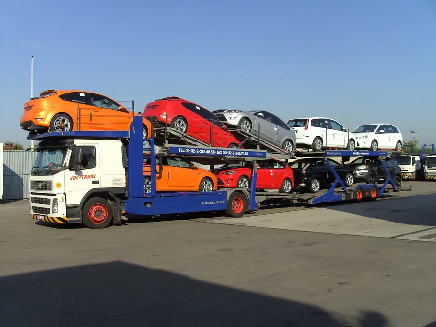 Plataforma abierta JDC-Trans Volvo FH cargada de 9 vehículos coloridos