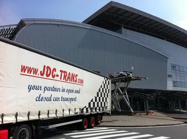Plateau ouvert JDC-Trans chargé de véhicules au départ d'une tournée européenne